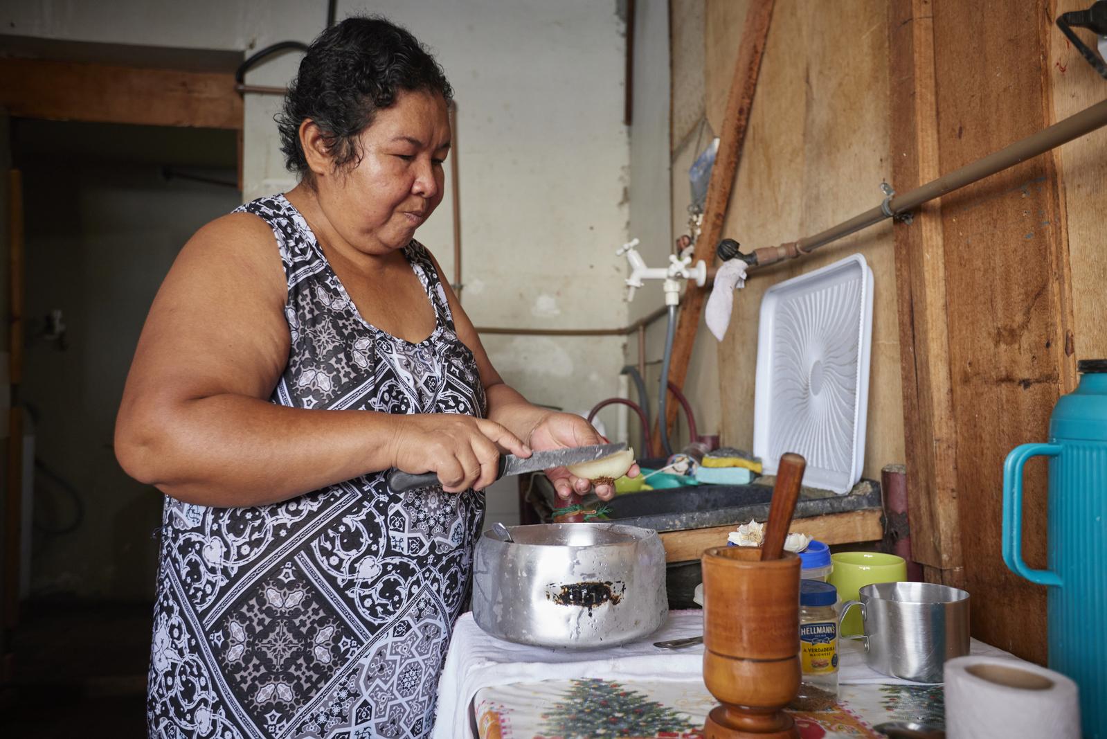 Vilma prepares lunch in her apartment in the Alcir Matos building.