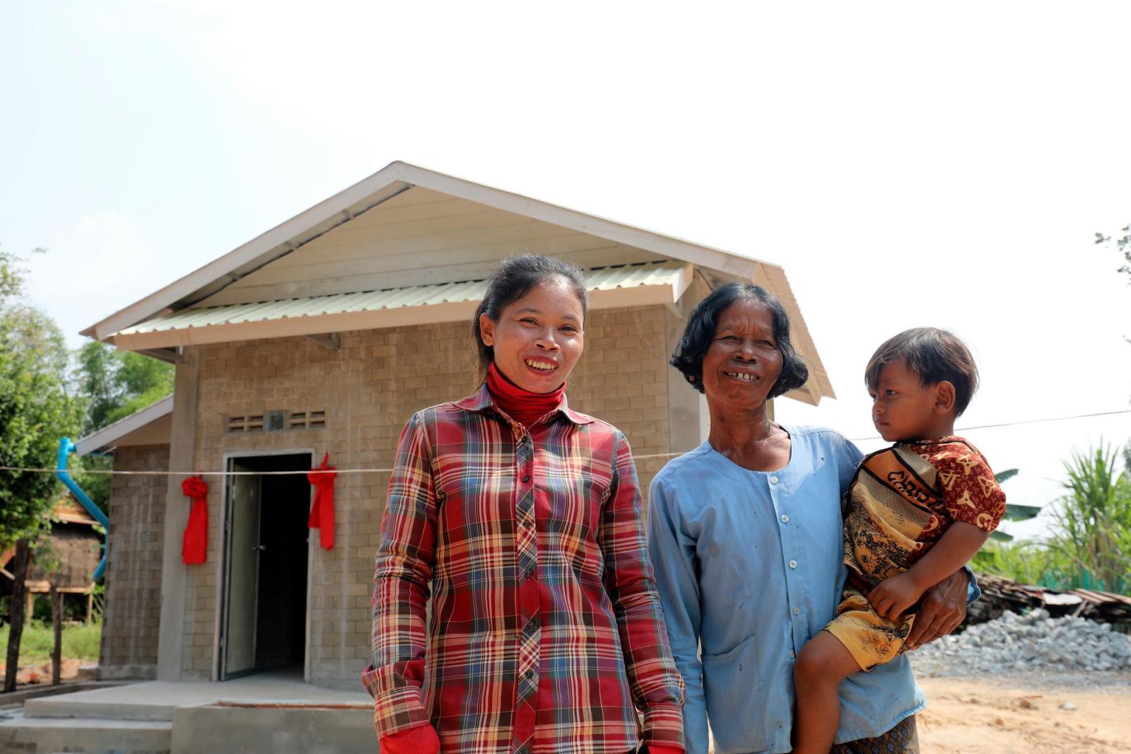 Von poses for a portrait with her daughter, Lam, and grandson, Sun, in front of their house in Siem Reap, Cambodia.