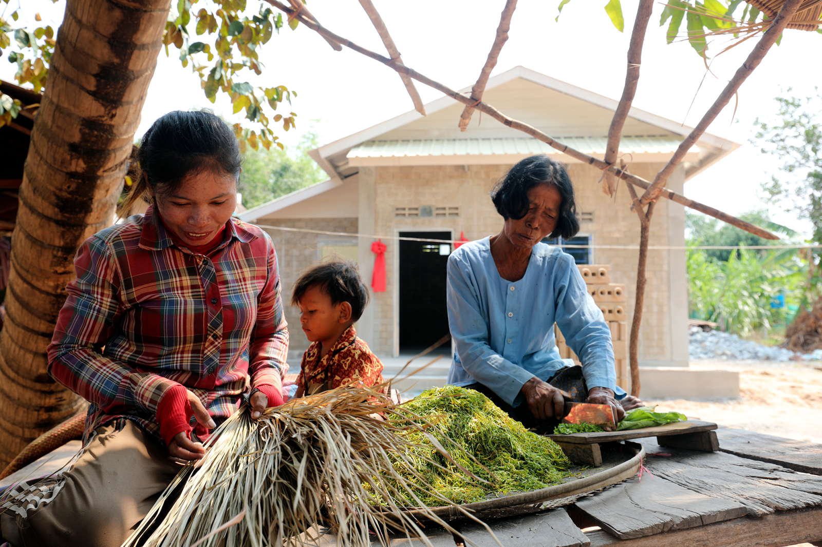 Von and her daughter Lam and grandson, Sun, work on making a handcrafted broom at their home in Siem Reap, Cambodia.