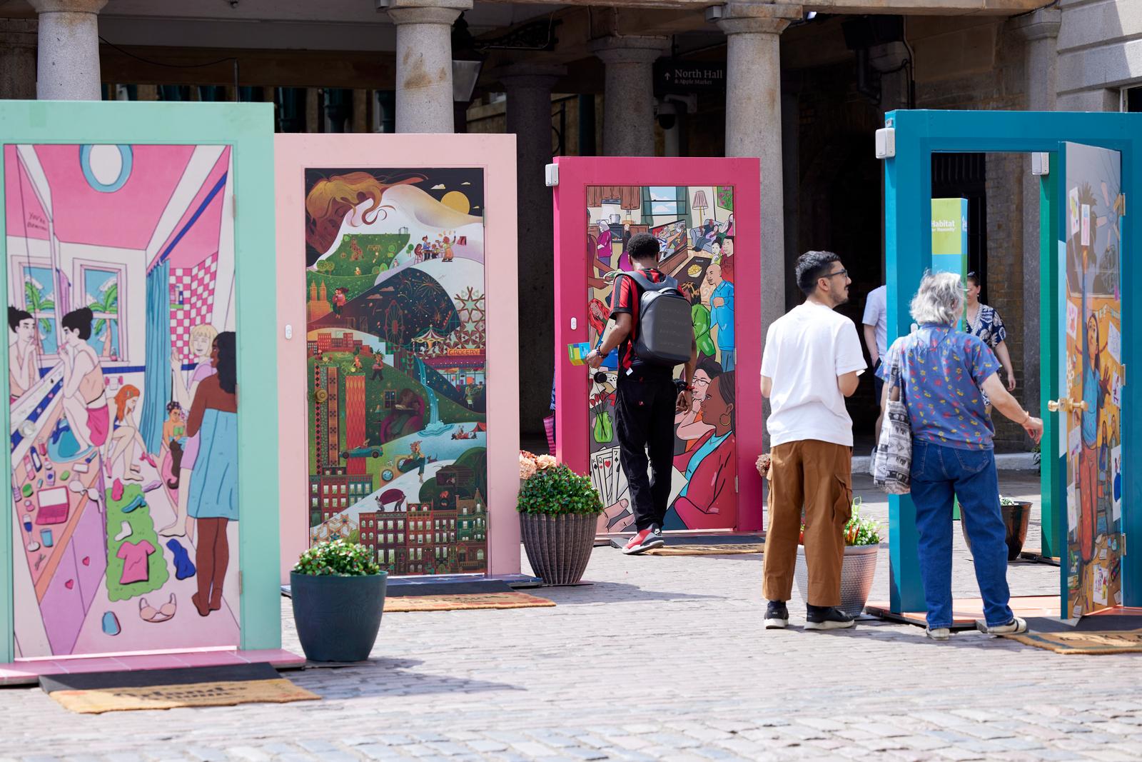 A man and a woman viewing a blue door surrounded by three other illustrated exhibit doors.
