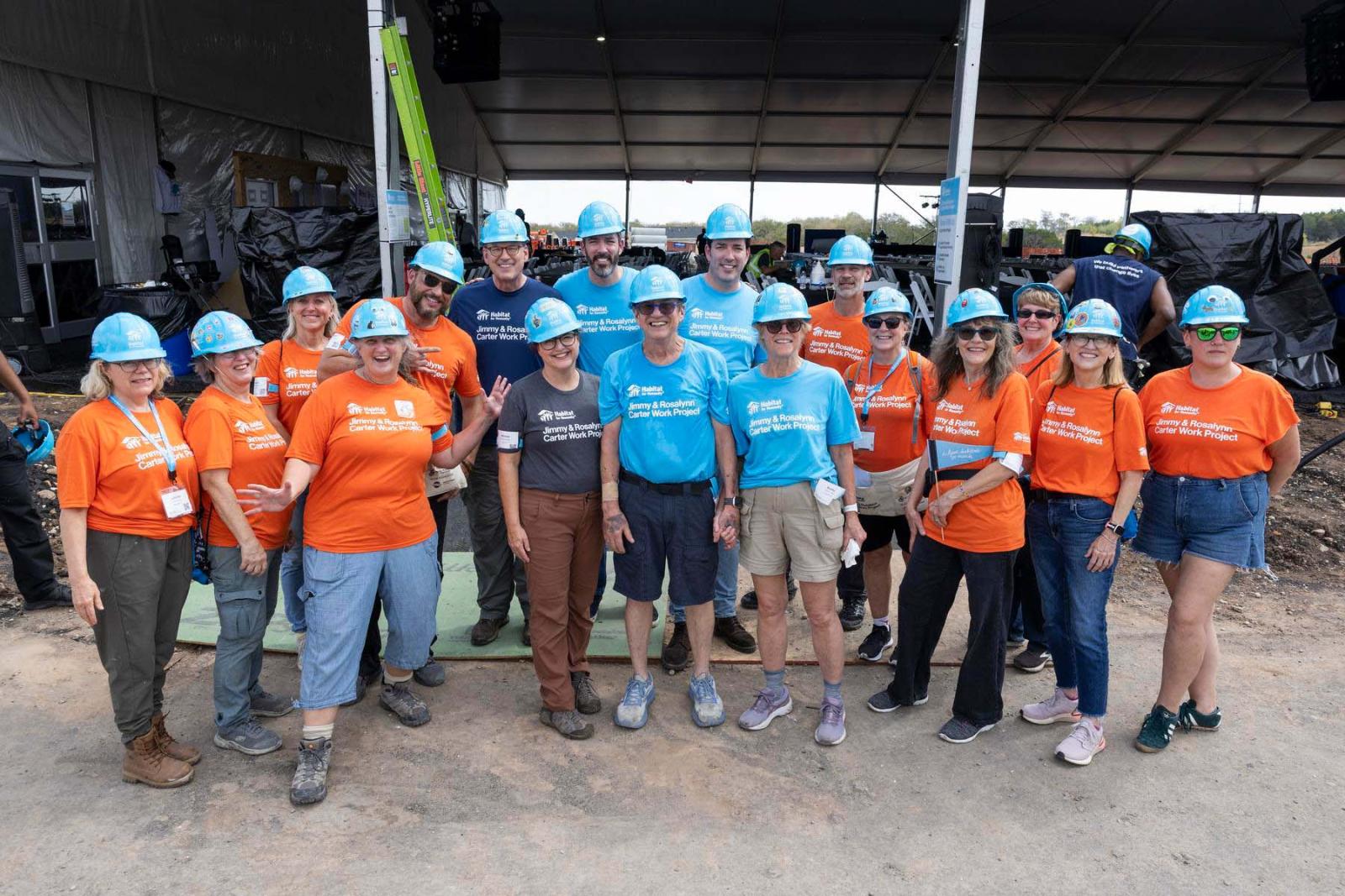 Hospitality volunteers pause and pose in a group at the Carter Work Project in Austin, Texas.