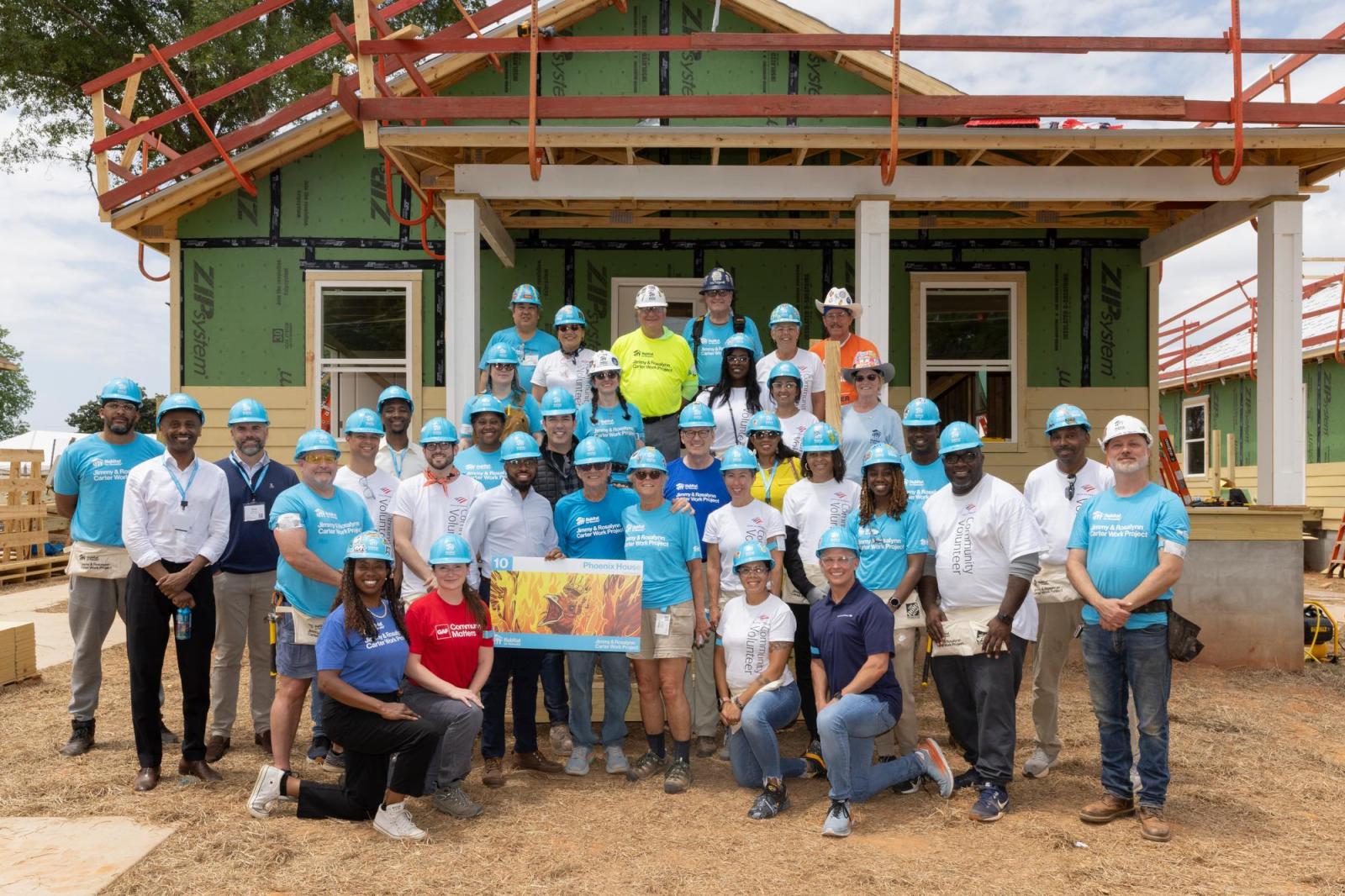 House 10 volunteers posing in front of house.