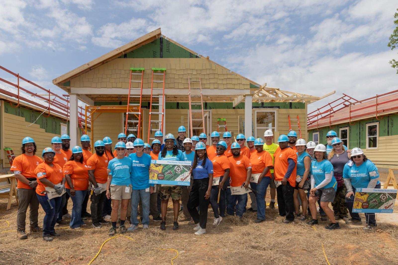 House 12 volunteers posing in front of house.