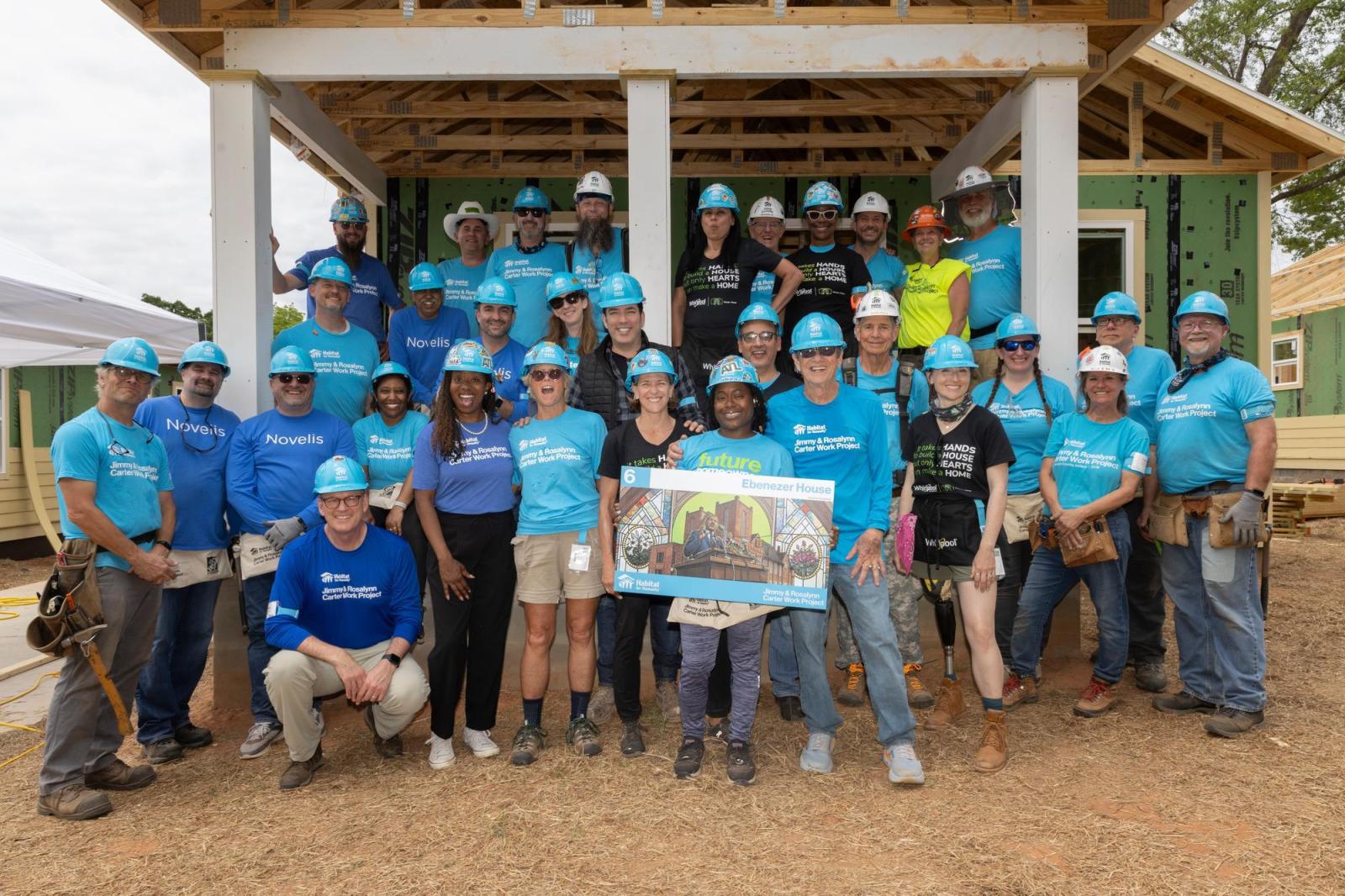 House 6 volunteers posing for group photo in front of house.