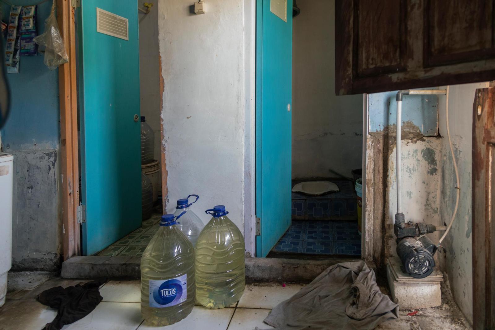 Bathroom in rental home with large bottles of water sitting nearby.