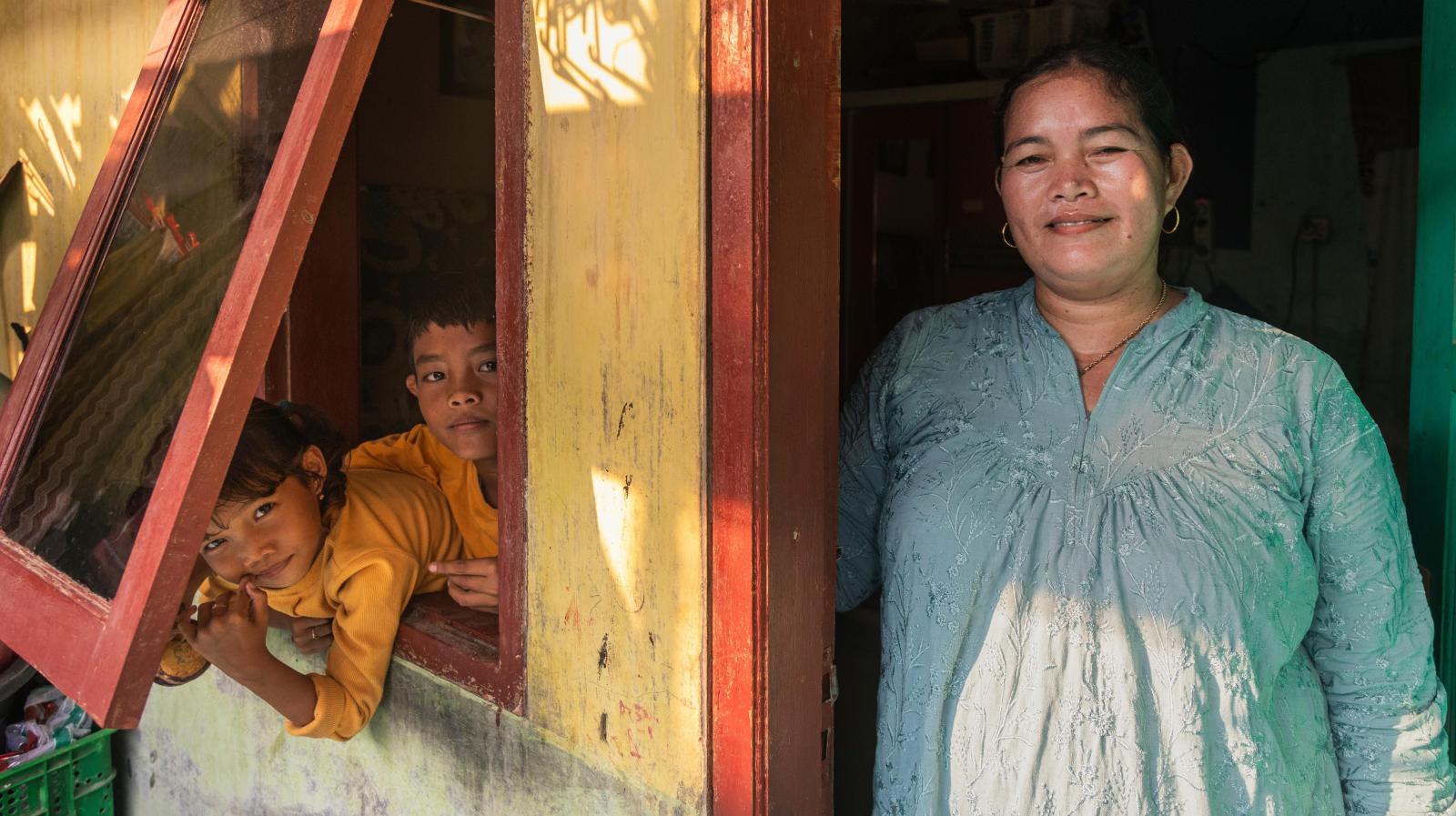 A portrait of Komariyah (38) and her two children in front of their rental home in Tanjung Kait, Banten, Indonesia.
