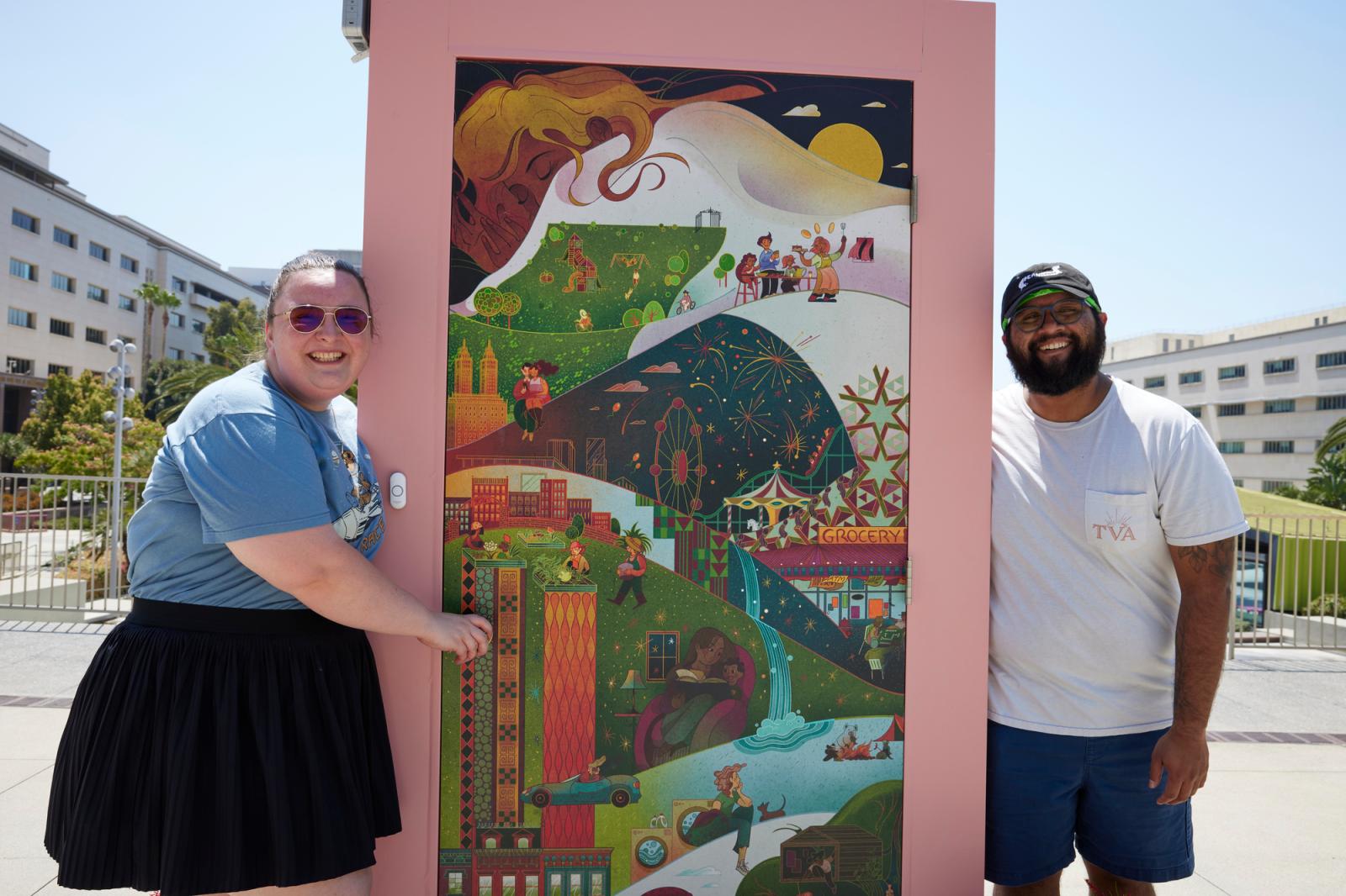 A woman in a black skirt and gray shirt on the left, an illustrated door in the middle and a man in a white shirt, hat and black shorts posing on the right.