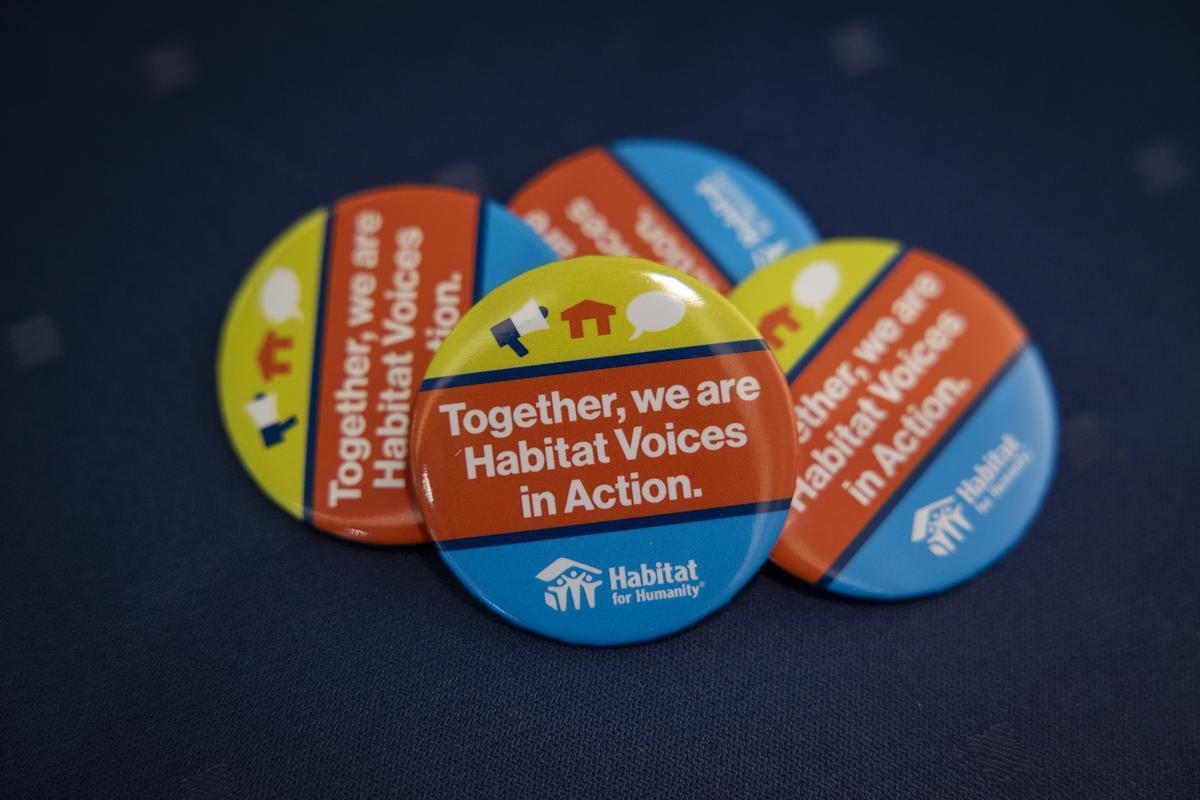 Pins reading "together, we are Habitat voices in action" are given out to attendees.