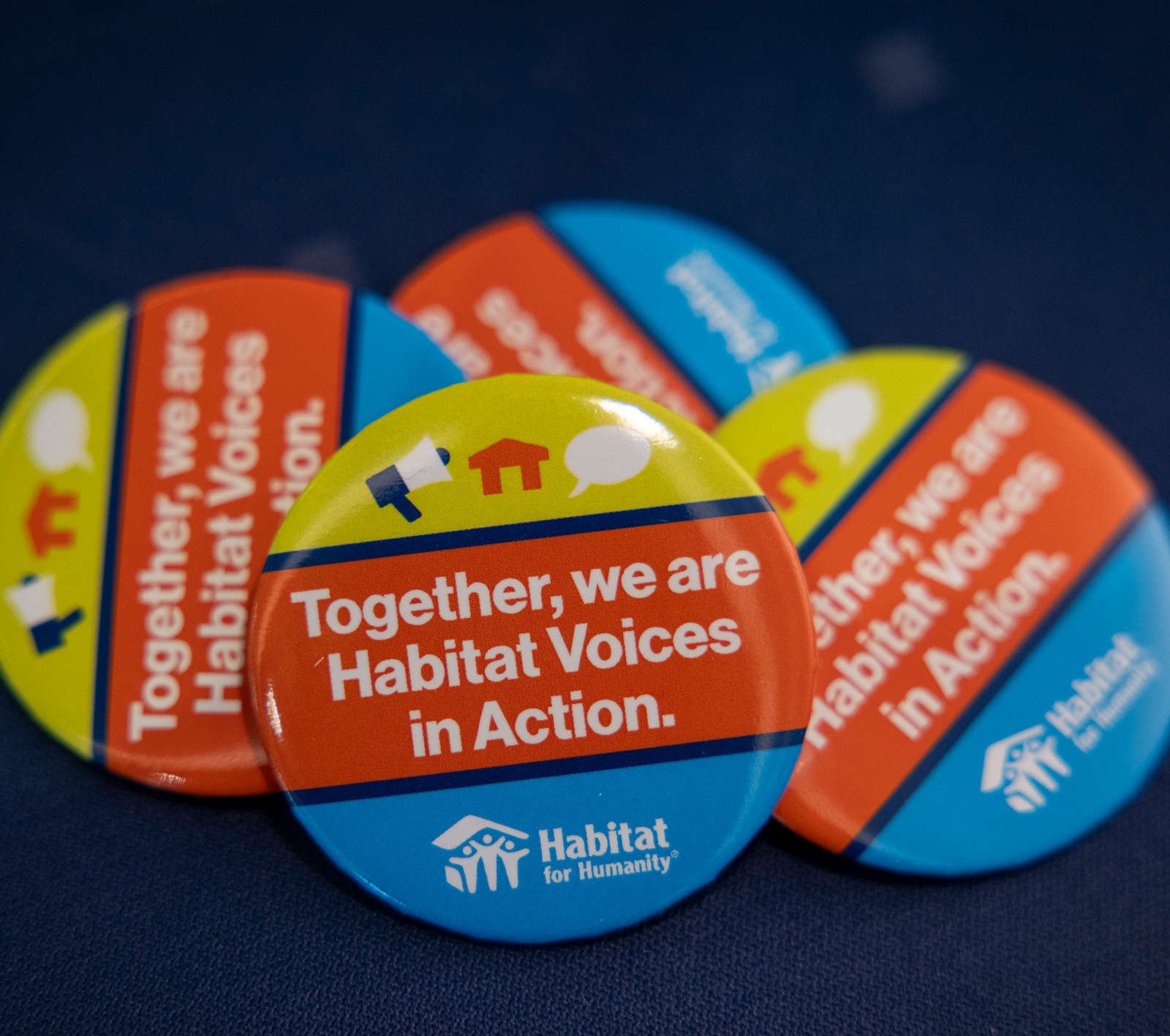 Buttons with the Habitat for Humanity logo that say, "Together, we are Habitat Voices in Action."