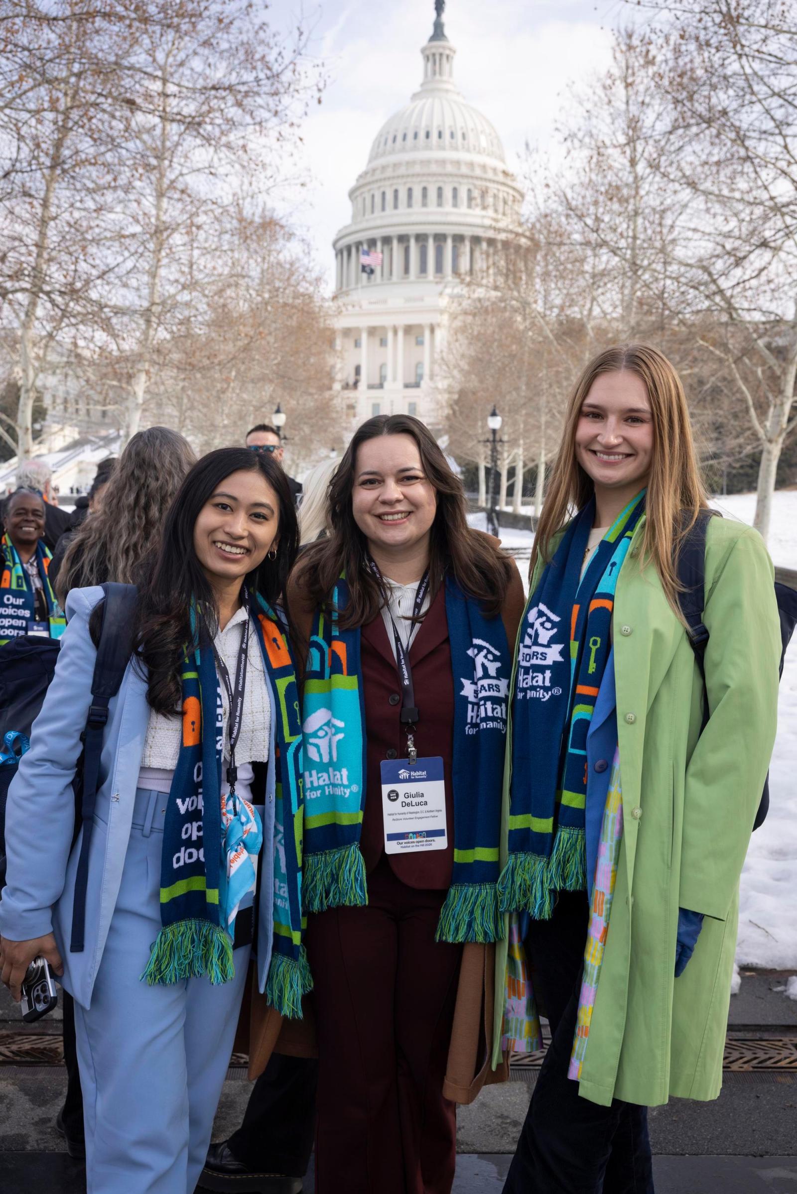 Three women posing in front of the Capitol building.