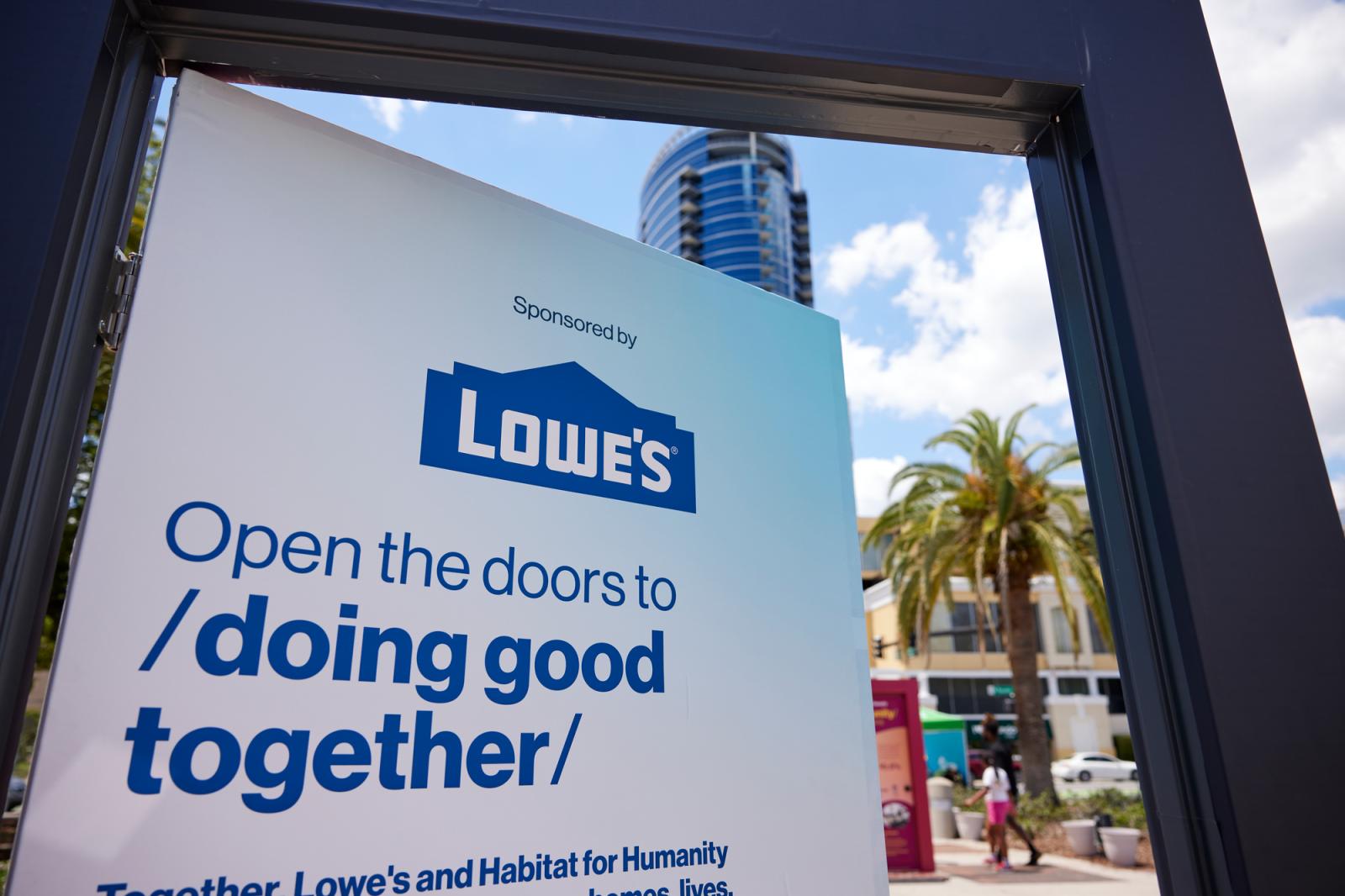 The upper part of a door sponsored by Lowes that reads, "Open the door to doing good together."