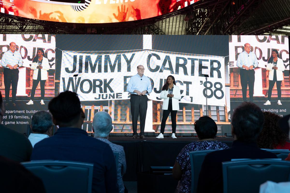 Jonathan Reckford, Habitat for Humanity International CEO, and Rosalyn Merrick, president and CEO, Atlanta Habitat for Humanity, address the crowd during the opening ceremony of the Jimmy and Rosalynn Carter Work Project at Mercedes-Benz Stadium in Atlanta, Georgia. 