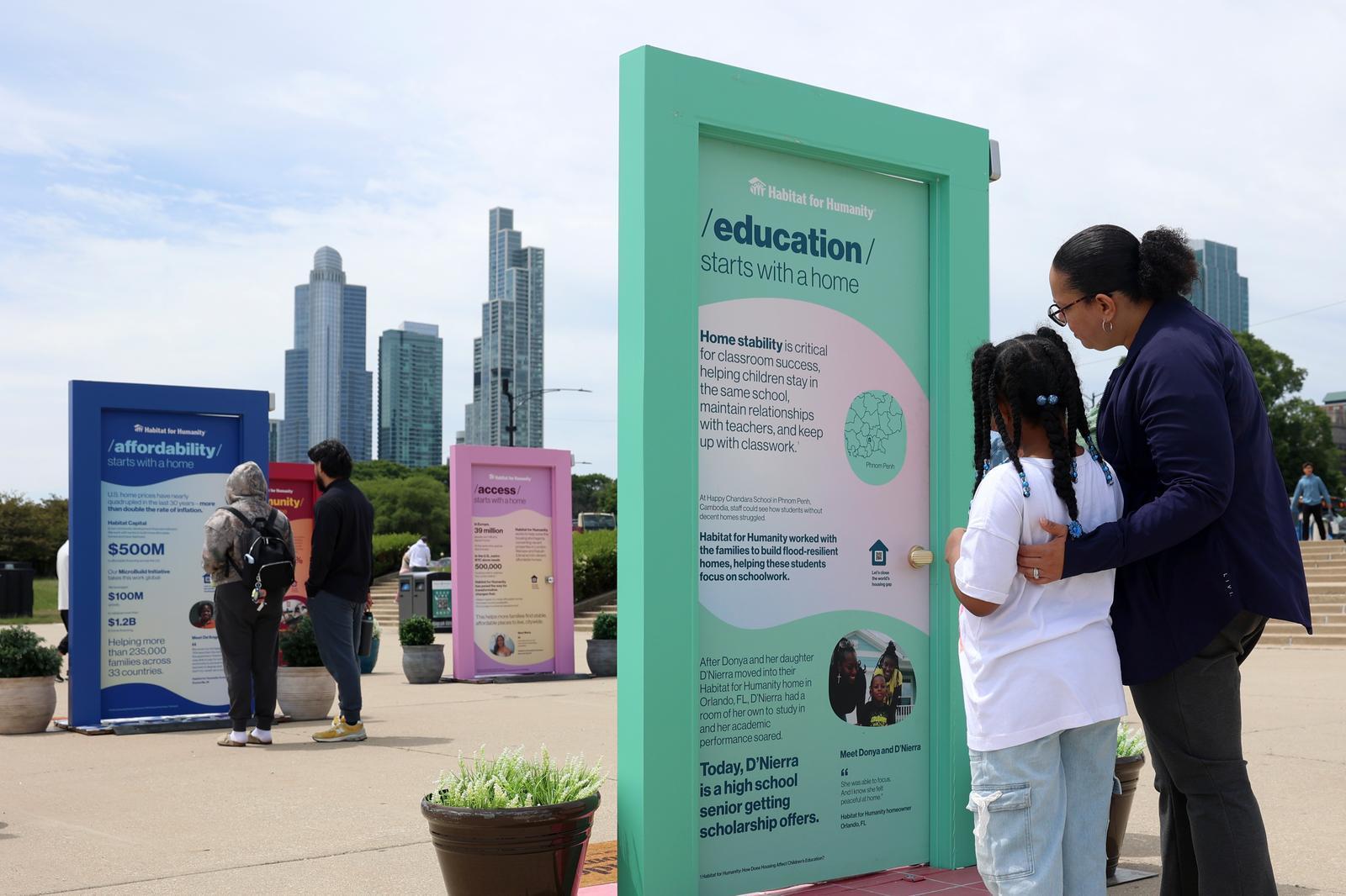 Mom and child viewing a mint green door with the Chicago skyline in the background. 