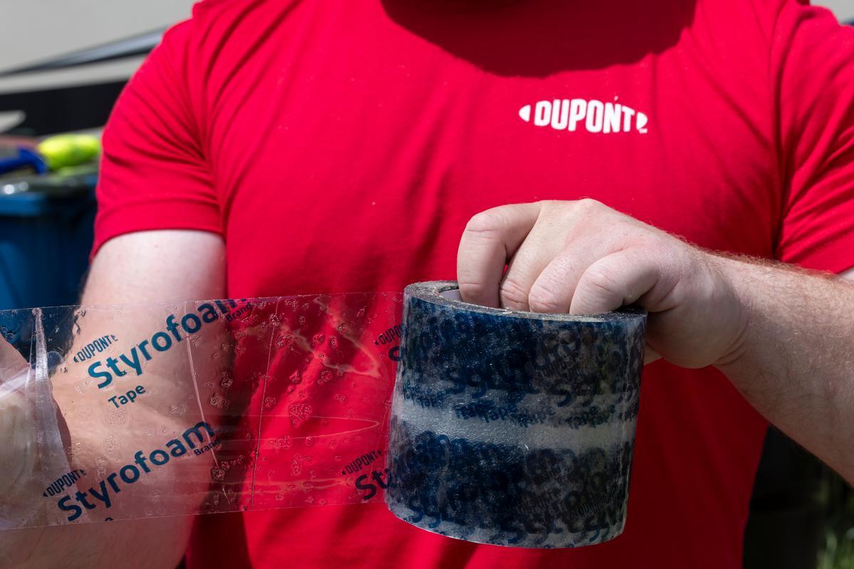 A DuPont volunteer installs DuPont Brand Styrofoam Tape