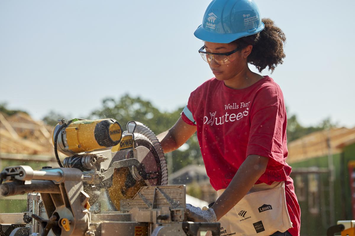 Volunteer using a saw