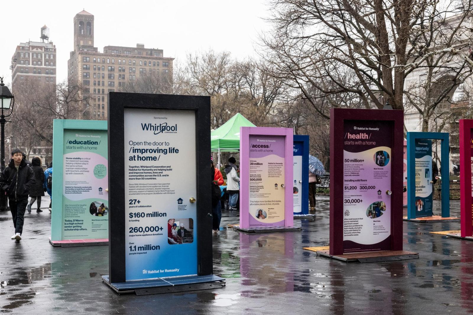 4 doors with various stats about what housing can do displayed in Washington Square Park.