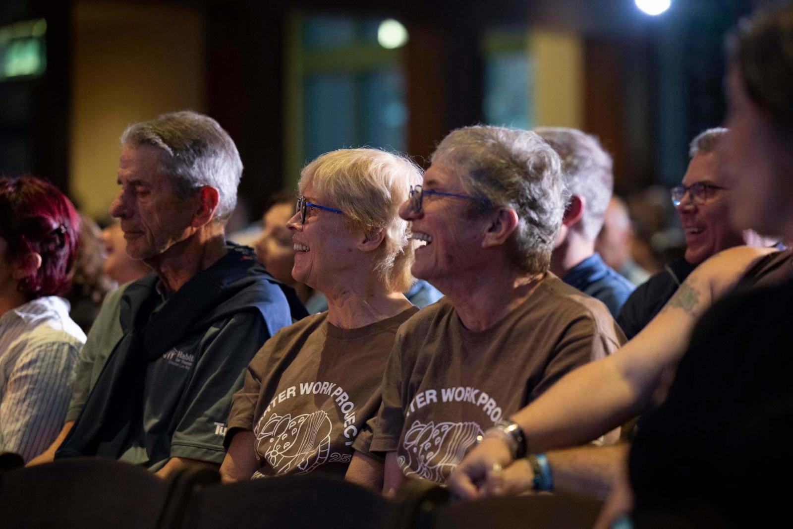 Chip Carter, son of President Jimmy Carter, sits with his wife Becky Carter in the audience staring up at the stage and smiling.