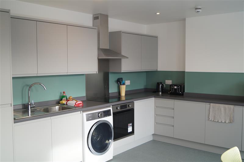 A refurbished kitchen with new appliances, new white and gray painted cabinets, and freshly painted walls.