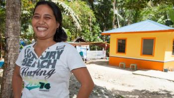 Homeowner in front of Habitat house