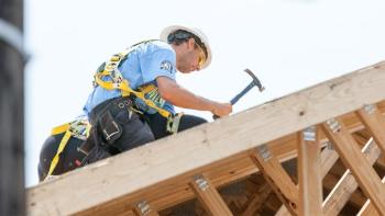AmeriCorps volunteer hammering on roof