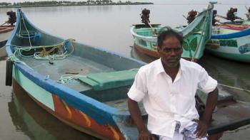 G. Sundaramurthy leaning on his fishing boat