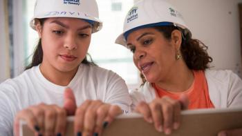 Future homeowners lift drywall