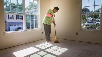 Homeowner sweeping her newly built house