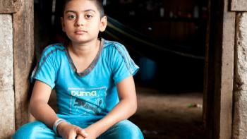 Young boy sits in doorway