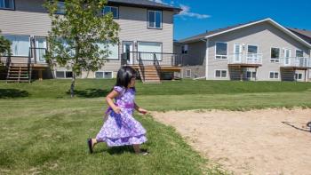 Child plays outside a Habitat house.