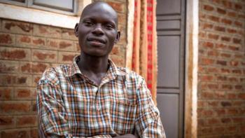Job Kalulu in front of his home