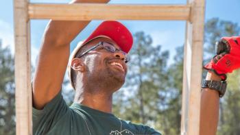Collegiate Challenge volunteer climbs ladder