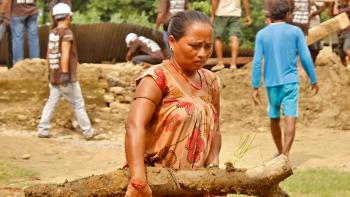 A woman helping to clear debris in flood-affected eastern Nepal.