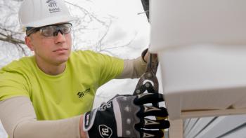 Volunteer clipping siding on a build site, Habitat for Humanity