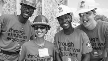 Diverse set of smiling volunteers on build site.