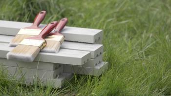 Paintbrushes and wood on grass