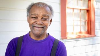 Walter stands on the front porch of his home, renovated with help from Habitat for Humanity