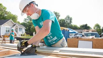 Volunteer measuring on build site.