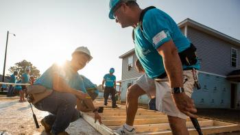 Future homeowner greets volunteers. 