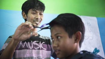 Habitat Indonesia homeowner Habib working in his barber shop. 