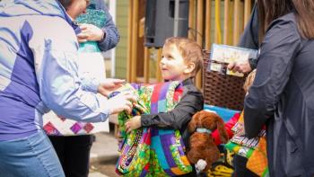 Little boy receives quilt.