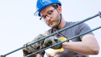 Man in hard hat on build site.