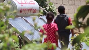 Photo: two children walking in green garden with solar panels