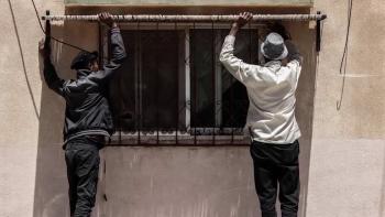 Photo: two men are adding window shading