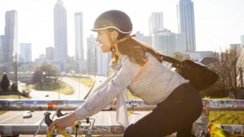Woman riding bike in city smiling.