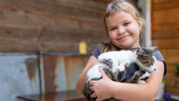 Miroslaw's daughter holding their pet cat.