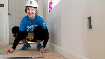 A teen lays flooring.