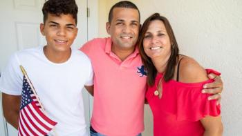 A family stands in front of their home.