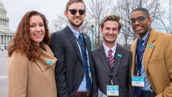 Four people standing together.