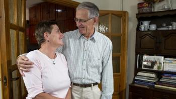 Jerzy and Alicja embracing in their home.