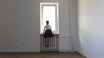 Young girl looking out window.